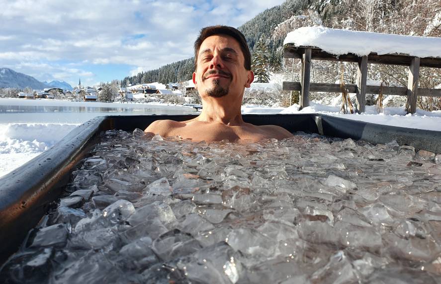 Mann in Eiswanne genießt die Sonne