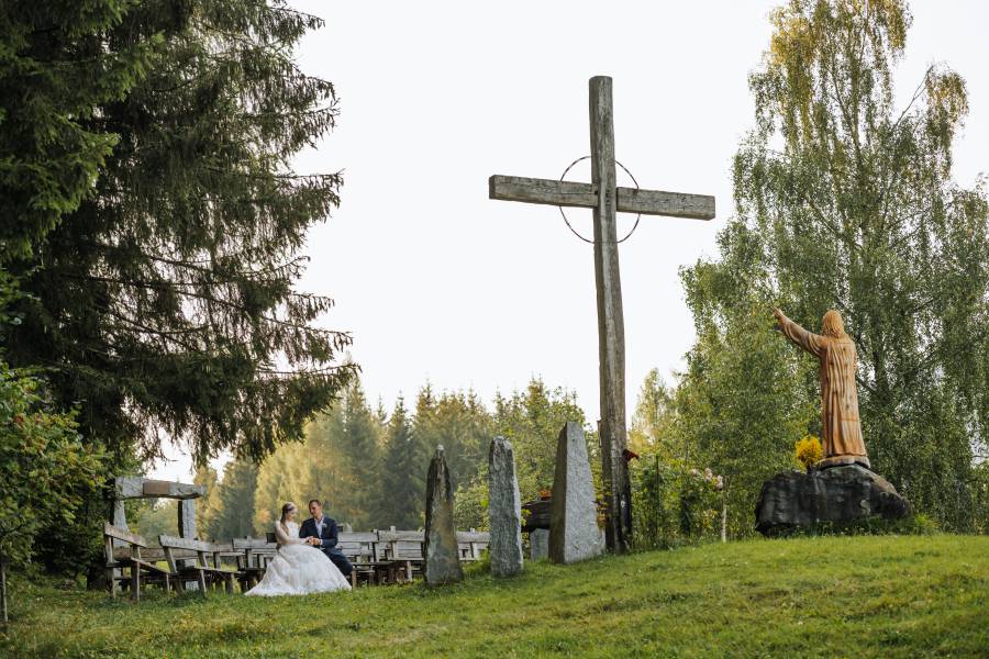 Brautpaar sitzt vor Kreuz in der Hoffnungskirche in Kärnten