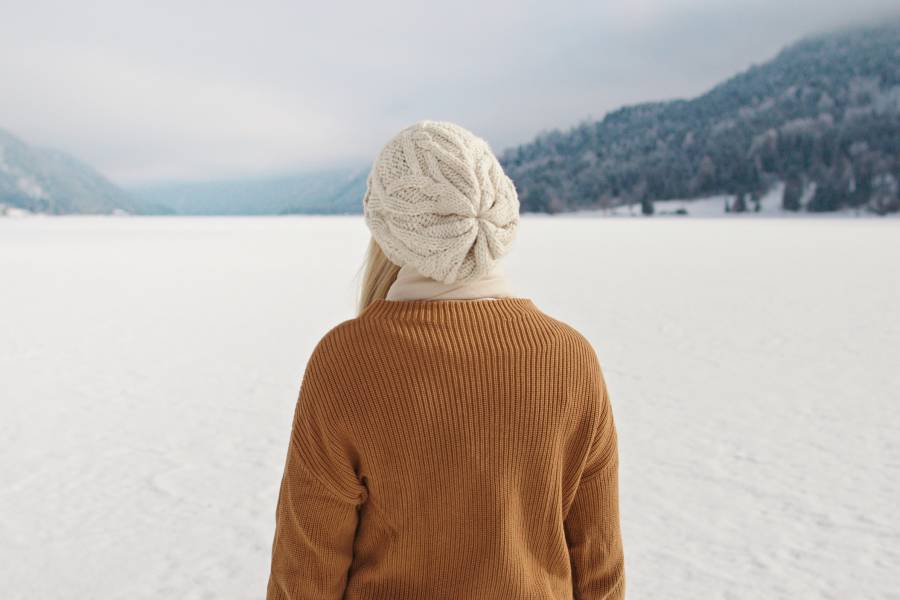 Frau steht im Winter am Weissensee